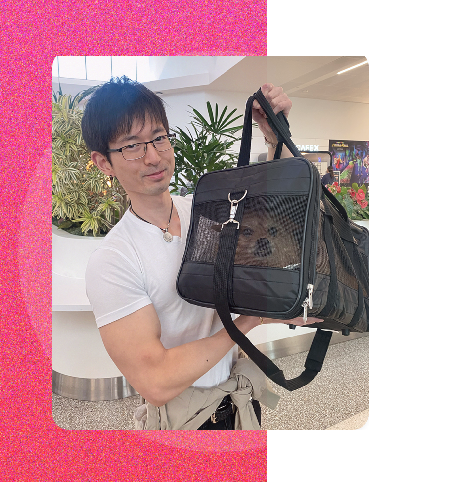 Joel holding his dog in a pet carrier